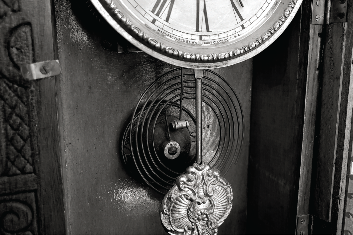 Black and white close up photo of the workings of a grandmother clock