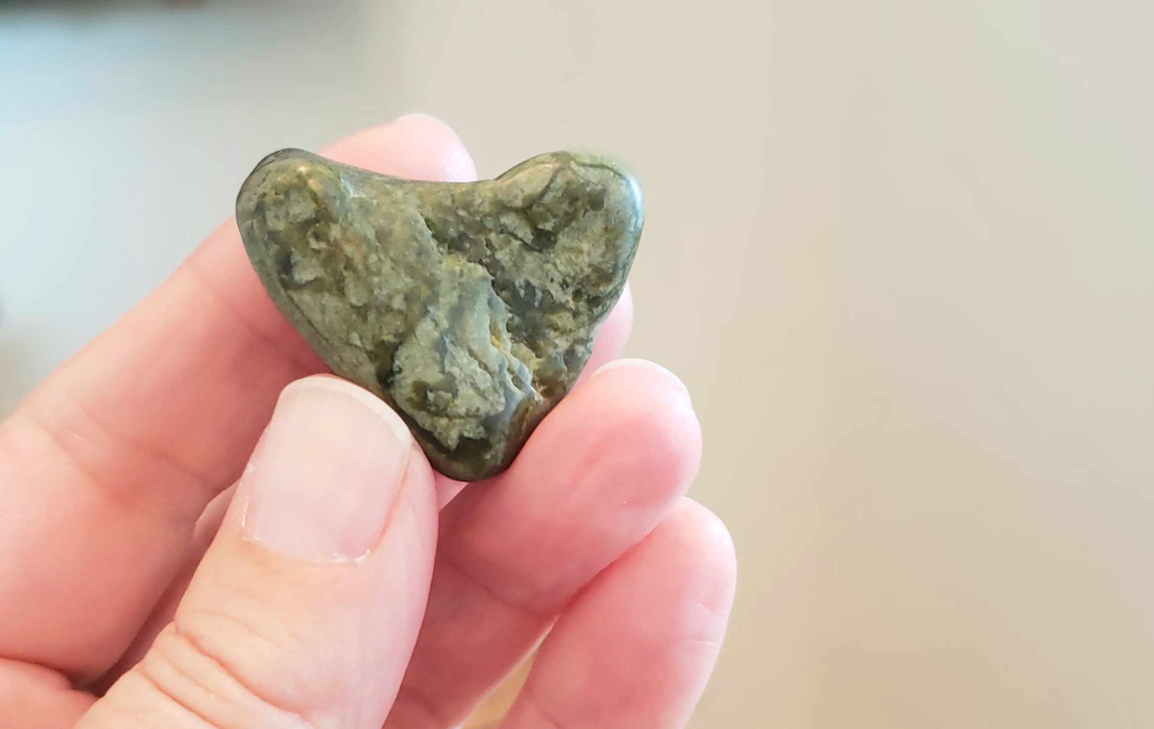 Colour photo of green heart-shaped rock.